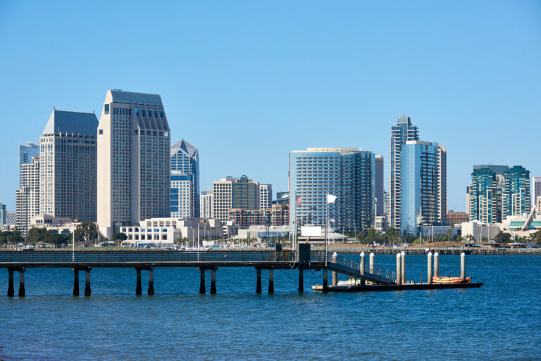 Pier with kayak boats, downtown skyline on background. San Diego, California
