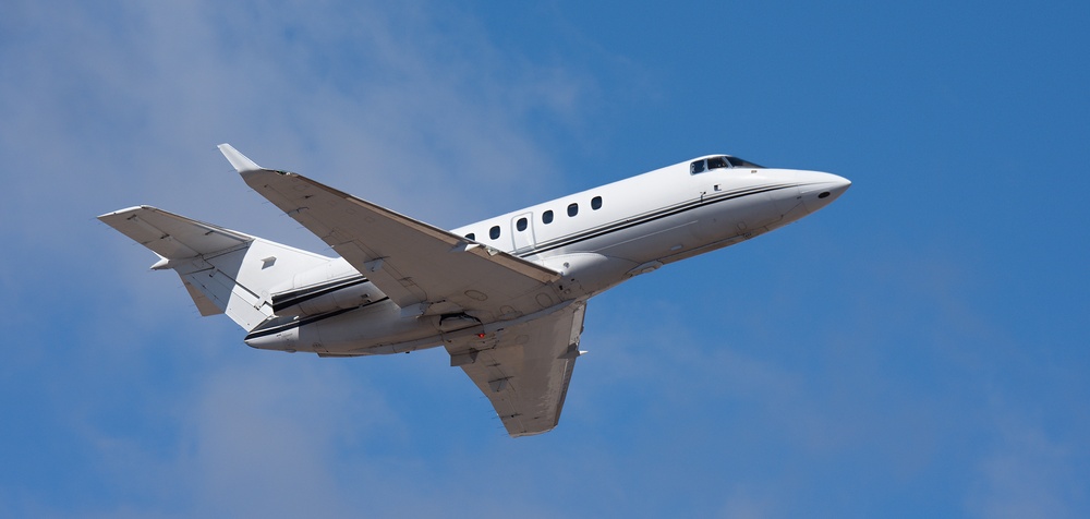 A midsize business jet climbing out after takeoff. Operators bill flight time, which is what this part of the trip costs.