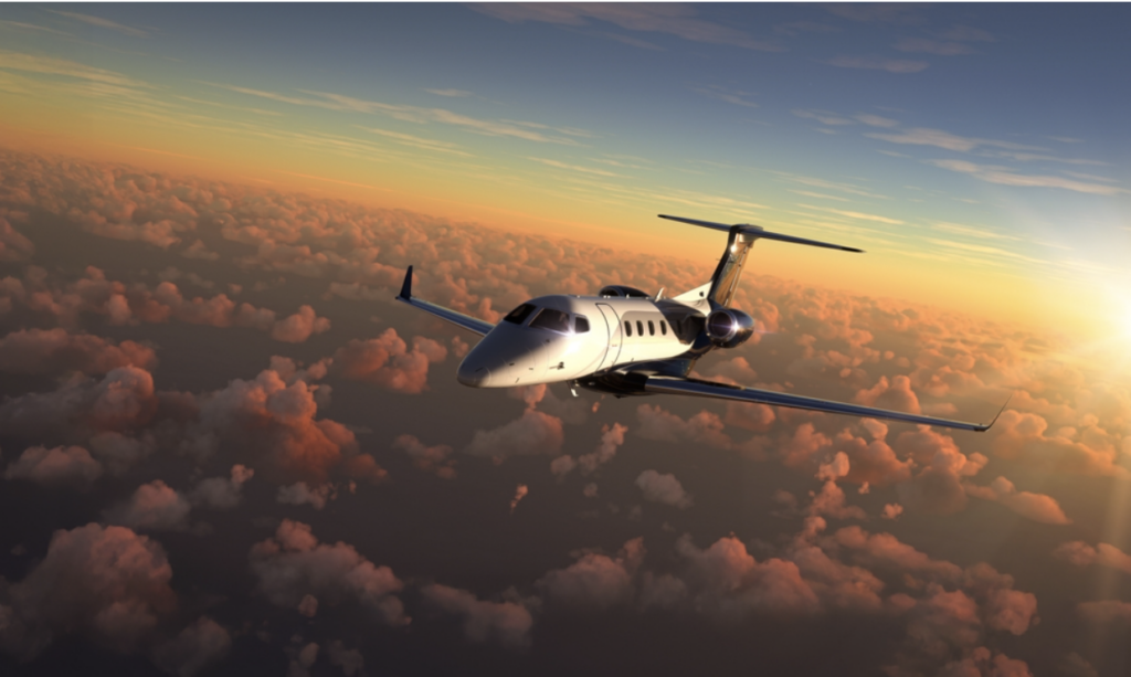 A private jet cruising at altitude above a layer of cloud, repositioning between charter assignments.