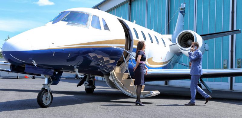 Young man having a call while embarking on business jet Young man having a call while embarking on executive jet